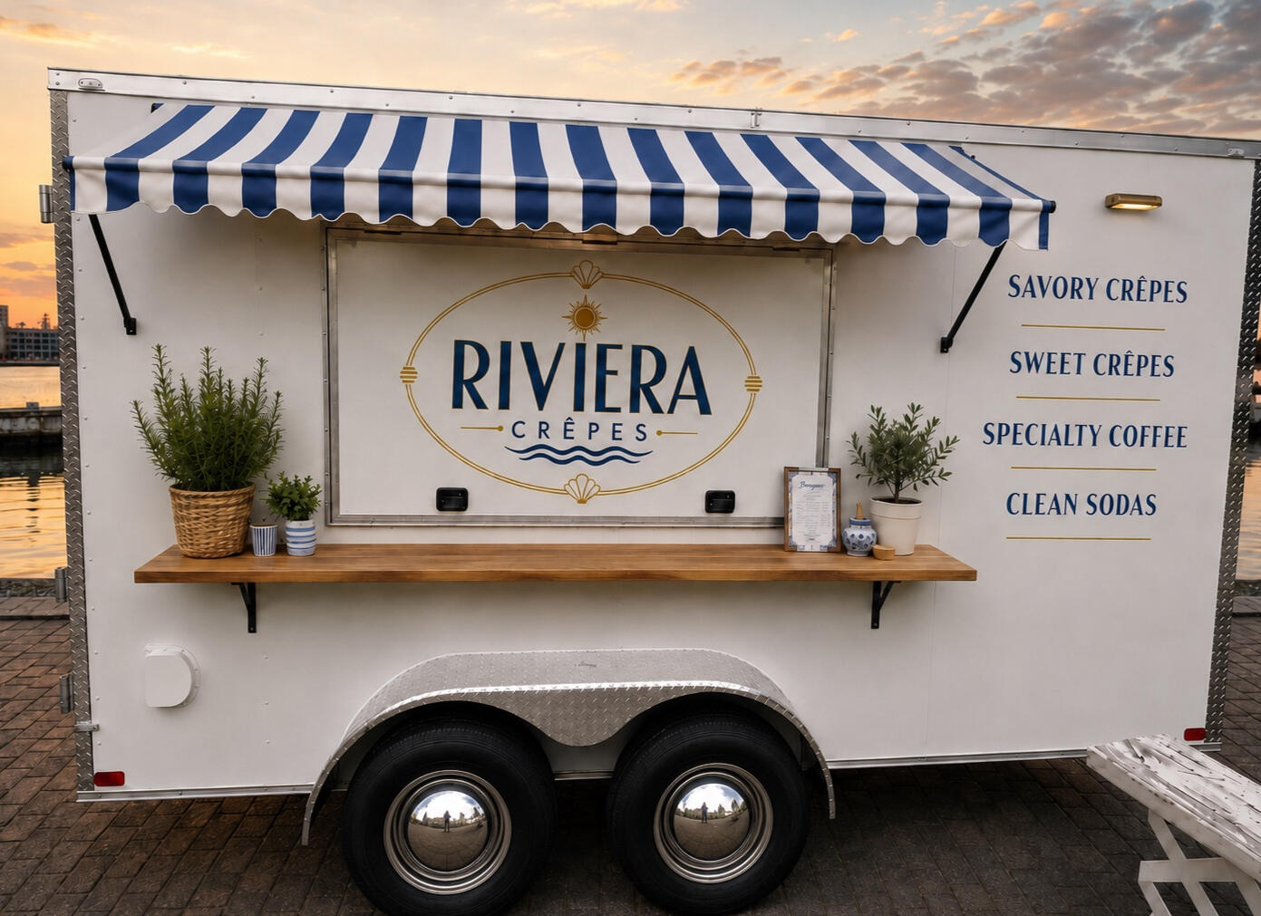 Riviera Crêpes trailer with navy striped awning by the waterfront